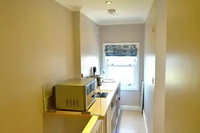 a small kitchen with a microwave on a counter at Avala in Perranporth