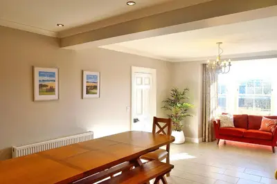 a living room with a wooden table and a chair at Avala in Perranporth