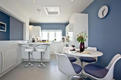 a kitchen with blue walls and a white table and chairs at Blue Bay, Marazion in Perranuthnoe