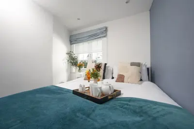 a bedroom with a large bed with a blue rug at Blue Bay, Marazion in Perranuthnoe