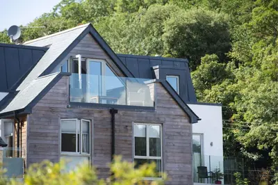 a house with a glass box on the roof at Fowey Penthouse, Fowey in Fowey