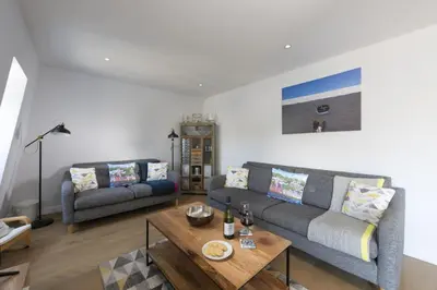 a living room with two couches and a coffee table at Fowey Penthouse, Fowey in Fowey