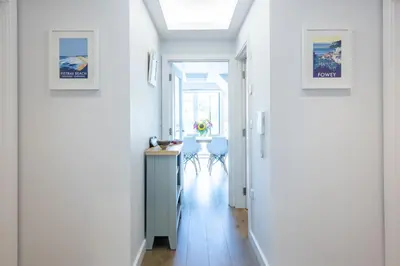 a hallway with white walls and a table in a room at Fowey Penthouse, Fowey in Fowey