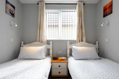 two twin beds in a room with a window at Cornish Holiday - 100 Hengar Manor in Bodmin