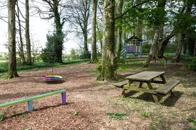 a park with a picnic table and a playground at Cornish Holiday - 100 Hengar Manor in Bodmin