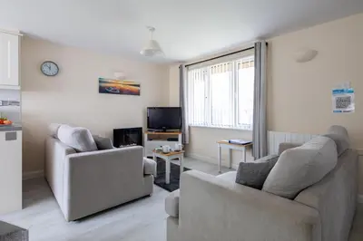 a living room with two chairs and a tv at Cornish Holiday - 100 Hengar Manor in Bodmin