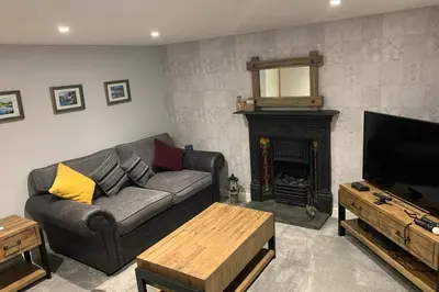 a living room with a couch and a fireplace at Beautiful Cottage in Central St Columb Major in Saint Columb Major