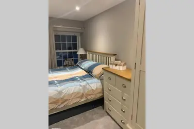 a bedroom with a bed and a dresser and a window at Beautiful Cottage in Central St Columb Major in Saint Columb Major