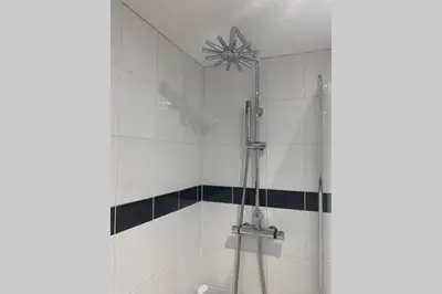 a shower in a white tiled bathroom at Beautiful Cottage in Central St Columb Major in Saint Columb Major