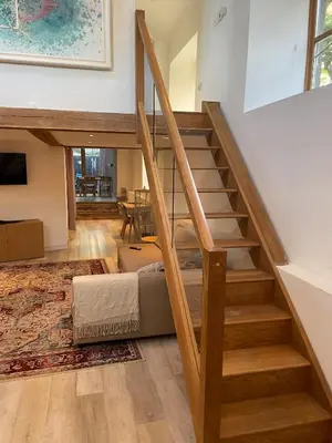 a room with a staircase with a bed and a table at Beautifully Converted Chapel in Blisland