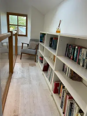 a room with white shelves filled with books at Beautifully Converted Chapel in Blisland