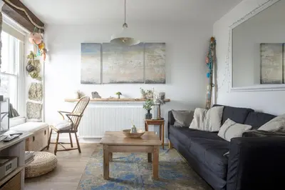 a living room with a blue couch and a table at 3 Victoria House in St Ives