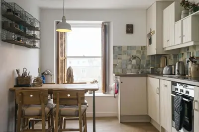 a kitchen with a table and chairs and a window at 3 Victoria House in St Ives