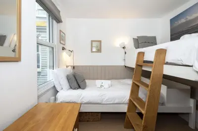 a small room with a bunk bed and a ladder at 3 Victoria House in St Ives