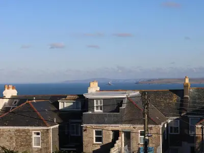 a group of houses with the ocean in the background at The Beach Hut in St Ives
