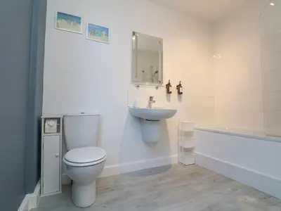 a bathroom with a toilet and a sink and a tub at The Beach Hut in St Ives