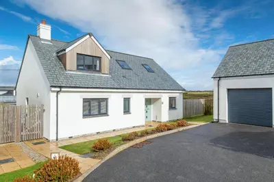 a white house with a garage at Endymion in Porthtowan