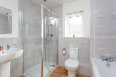 a bathroom with a toilet and a shower and a sink at Endymion in Porthtowan