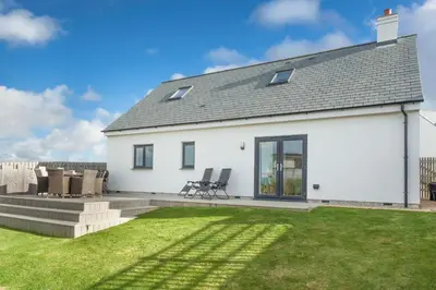 a white house with a lawn in front of it at Endymion in Porthtowan