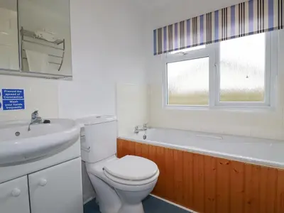 a bathroom with a toilet and a sink and a tub at Summer Breeze in Padstow