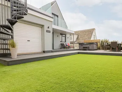 a backyard with a lawn and a house at Pepperpots in Newquay