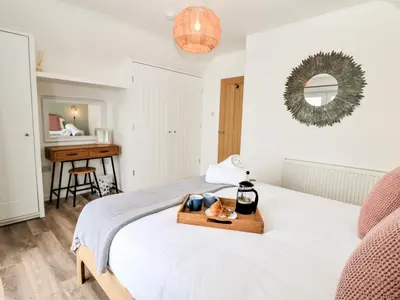 a bedroom with a bed with a wooden tray on it at Pepperpots in Newquay