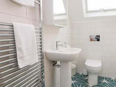 a white bathroom with a sink and a toilet at Pepperpots in Newquay