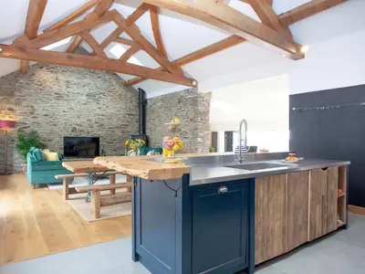 a kitchen with wooden beams and a living room at Vredehoek in Quethiock