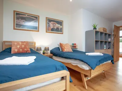 a bedroom with two beds with blue sheets at Vredehoek in Quethiock