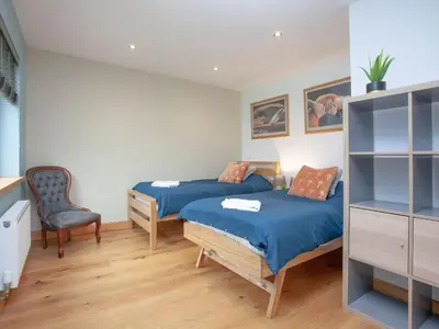 a bedroom with two beds and a chair at Vredehoek in Quethiock