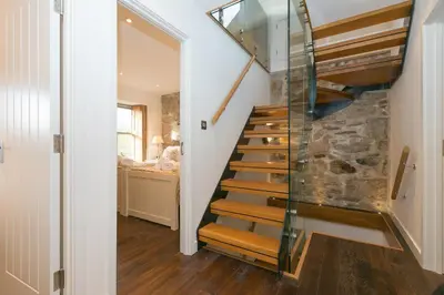 a staircase in a home with a glass railing at Penhaven in St Ives