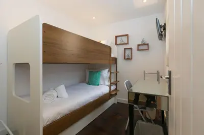a small bedroom with a bed and a desk at Penhaven in St Ives