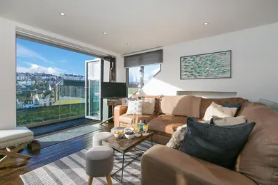 a living room with a couch and a large window at Penhaven in St Ives