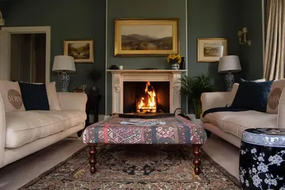 a living room with a fireplace with a fire pit at The Manor House at Boconnion in Bodmin