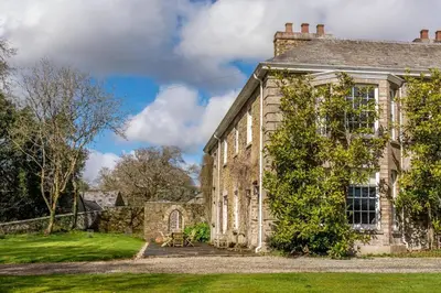 an old stone house with a green yard at The Manor House at Boconnion in Bodmin