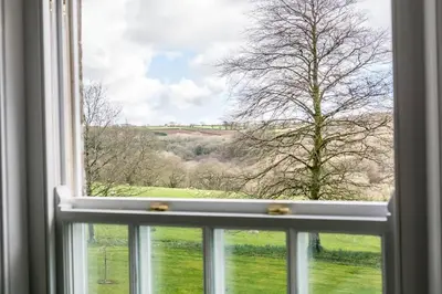 a window with a view of a field and trees at Boconnion Estate Sleeps up to 45 in Bodmin