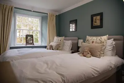 a bedroom with two beds with a teddy bear sitting on them at Boconnion Estate Sleeps up to 45 in Bodmin