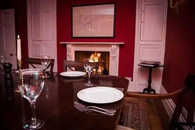 a dining room with a table and a fireplace at Boconnion Estate Sleeps up to 45 in Bodmin