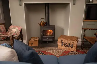 a living room with a fireplace and a stove at Boconnion Estate Sleeps up to 45 in Bodmin