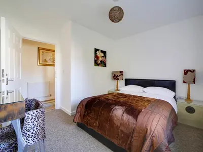 a bedroom with a large bed and a desk at Wheel Water Collections in St Austell