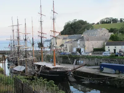 a large boat docked in a marina next to houses at Wheel Water Collections in St Austell