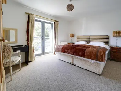 a bedroom with a bed and a desk and a window at Wheel Water Collections in St Austell