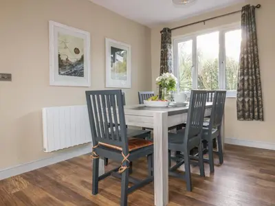 a dining room with a table and four chairs at Crantock Lodge in Newquay