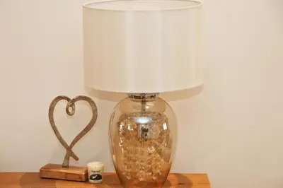 a glass lamp sitting on a table next to a heart decoration at NEAR BEACHES, contemporary home in village centre in St Merryn