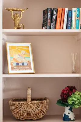 a book shelf with books and a basket on it at Stunning views over the beautiful Falmouth Harbour in Falmouth