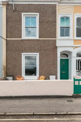 a building with two windows and a green door at Stunning views over the beautiful Falmouth Harbour in Falmouth