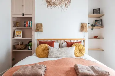 a bedroom with a bed with orange and white pillows at Stunning views over the beautiful Falmouth Harbour in Falmouth