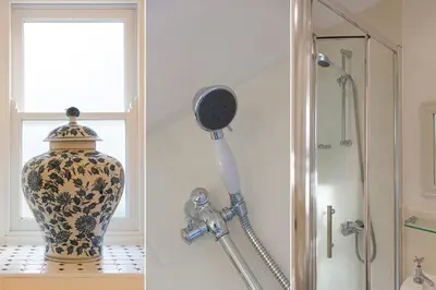 a vase sitting on a shelf next to a shower at Breaking Waves in St Ives