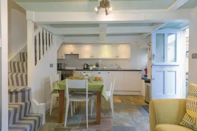 a kitchen and dining room with a table and chairs at Breaking Waves in St Ives