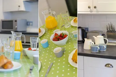 a kitchen counter with a table with fruit and orange juice at Breaking Waves in St Ives